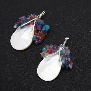 Detail van met draad omwikkelde hangers van natuurlijke schelp met gekleurde steentjes