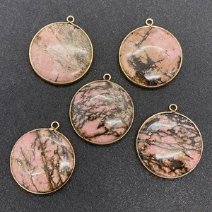 Vue macro de 5 pendentifs ronds en rhodonite avec bordure métallique dorée pour bijoux