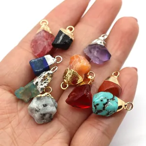 Lot de pendentifs en pierres naturelles avec fermoir en métal tenus dans la main