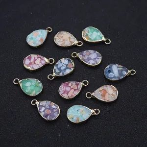 Détail de pendentifs en forme de goutte d'eau avec cadre doré et pierres multicolores
