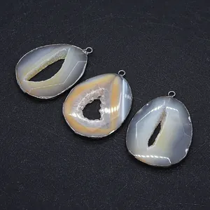 Detailed close-up of three irregular druzy agate pendants with grey metal plating
