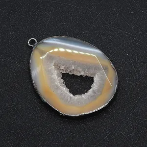 Close-up of a natural agate druzy pendant with metallic edging and crystal core
