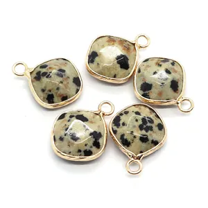Five square Dalmatian Jasper pendants with gold metal edges on a white background