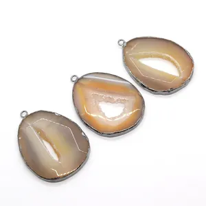 Set of three irregular druzy agate slice pendants with silver plated edges on white background
