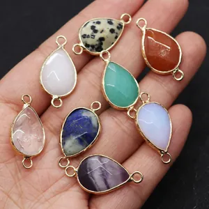 Macro shot of colorful natural stone teardrop pendants with gold plated double rings