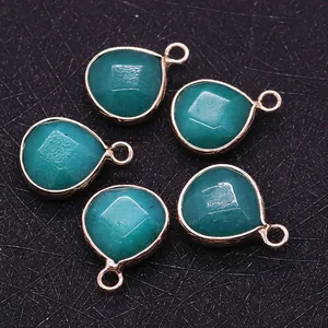 Detail of five faceted teal gemstone teardrop pendants with gold plated metal edges