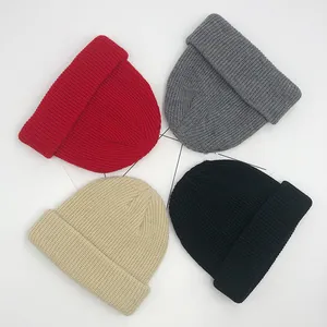 Vue détaillée à plat de quatre bonnets en maille côtelée en rouge, gris, beige et noir