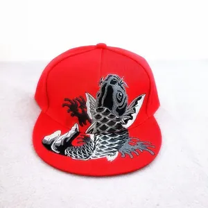 Red snapback baseball cap featuring detailed koi fish embroidery in a flat-brim style