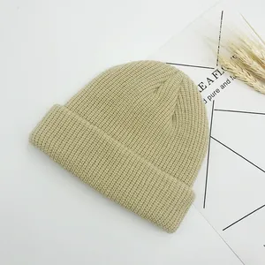 Gros plan sur le bonnet en maille côtelée beige avec texture douce et revers replié