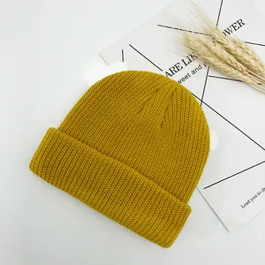 Détail du bonnet en tricot jaune gingembre avec texture côtelée et revers