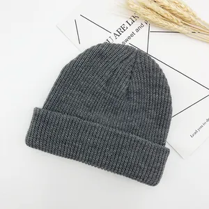 Gros plan sur un bonnet en maille gris foncé avec texture côtelée et bord plié