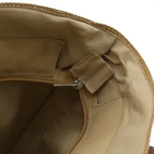Interior view of the woven tote bag showing brown lining with a zipper pocket and slit pocket