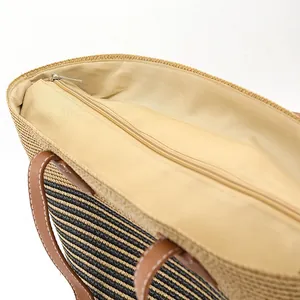 Bohemian striped straw tote bag with brown leather handles and zipper closure