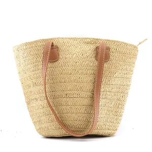 Bohemian striped straw tote bag with brown leather handles and zipper on white background