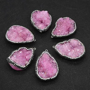 Detailed view of pink natural geode pendants with black metal edging and crystals