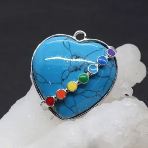 Close-up of heart-shaped turquoise stone pendant with seven chakra stones and silver frame