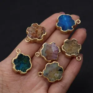 Macro shot of assorted natural crystal pendants with gold edges held in hand for DIY jewelry