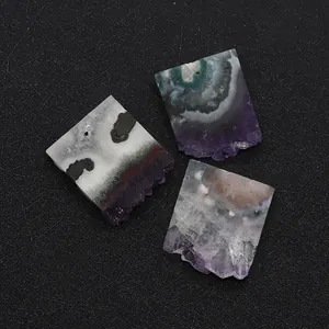 Détail macro de tranches d'améthyste naturelle avec trou de perçage sur fond noir