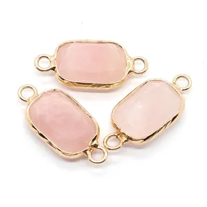 Dettaglio di tre connettori in pietra rosa sfaccettata con bordi dorati per gioielli
