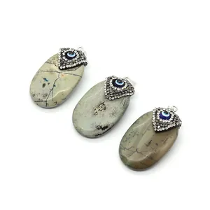 Natural oval turquoise stone pendant with silver evil eye cap and sparkling rhinestones