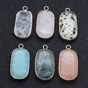 Set aus sechs ovalen Natursteinanhängern mit elegantem Goldrand auf schwarzem Displaypad