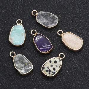 Detailed view of irregular teardrop pendants with gold edges and natural stones