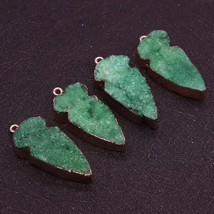 Macro-detail van vier groene druzy kristallen pijlhangers met roségouden metalen rand