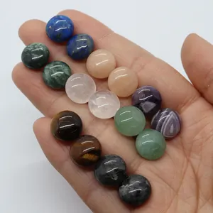 Dettaglio di vari cabochon in pietra naturale da 12mm tenuti in mano per confronto dimensioni