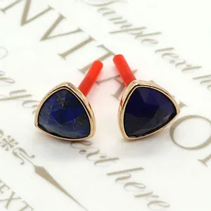Detalle macro de pendientes triangulares de lapislázuli con bisel dorado decorativo