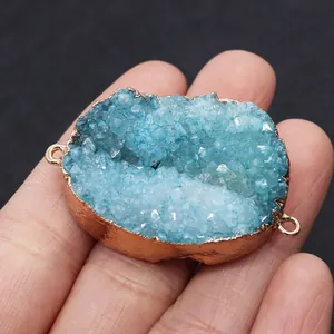 Macro shot of light blue druzy stone connector with rose gold trim held in hand