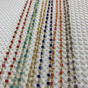 Primer plano de cuentas cúbicas coloridas y cadenas doradas para creación de joyería DIY