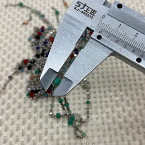 Detail shot measuring 4mm faceted natural stone beads on a silver beaded chain link
