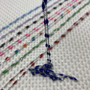 Macro shot of silver stainless steel chains with colorful enamel oval beads for DIY jewelry