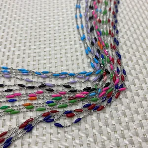Detail of colorful oval enamel rice beads on a silver stainless steel link chain roll