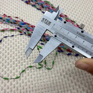 Detailed view of colorful rice-shaped beads on a stainless steel chain with a caliper measurement