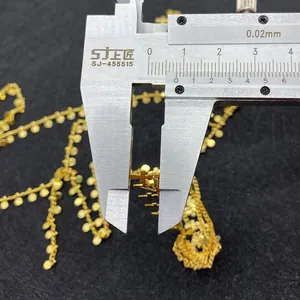 Detail showing measurement of gold cross charms on a twisted chain necklace accessory