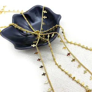 Gold plated twisted chain necklace with cross and round charms on black jewelry tray