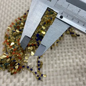 Κοντινή λήψη πολύχρωμης αλυσίδας με χάντρες, χρυσά μενταγιόν και παχύμετρο μέτρησης