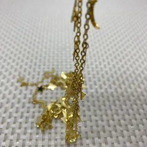 Macro shot of gold star and moon charms on metal chain for DIY jewelry making