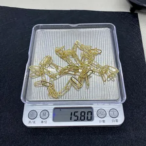 Macro di una catena a graffetta dorata da 15,80 g pesata su una bilancia digitale