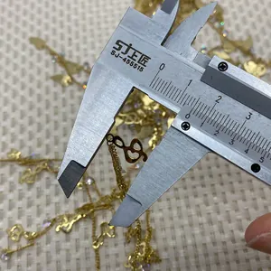 Detailed measurement of gold-plated music note and heart charm using a digital caliper