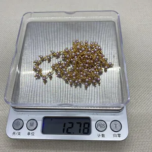 Detailed view of copper chain with purple pearls on an electronic scale weighing 12.78g