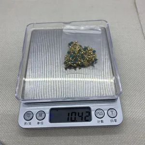 Macro-opname van gouden gedraaide ketting met natuurstenen gewogen op een weegschaal