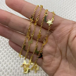 Golden chain necklace with star, crescent moon and lightning charms held by hand