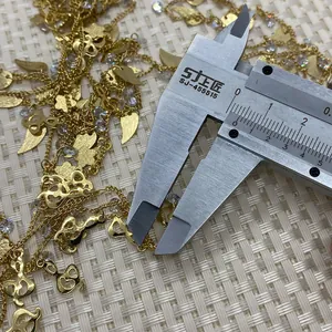 Macro shot measuring the golden treble clef pendant size with a digital caliper