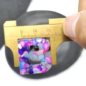 Detail showing measurement of letter B resin pendant with colorful gravel fill
