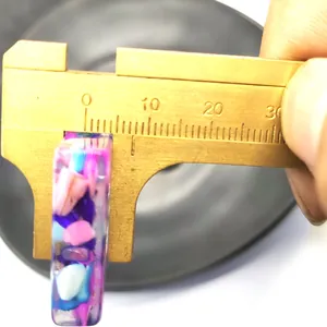 Macro shot showing the 5-7mm width measurement of a colorful resin crushed stone pendant