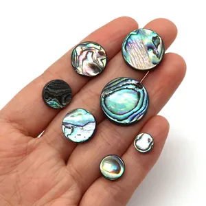 Macro view of natural iridescent abalone shell round beads in assorted sizes for DIY crafts