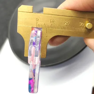 Misurazione dettagliata dell'anello in resina colorata da 8mm con un calibro in ottone