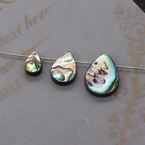 Trois perles en nacre d'abalone en forme de goutte montrant un éclat iridescent